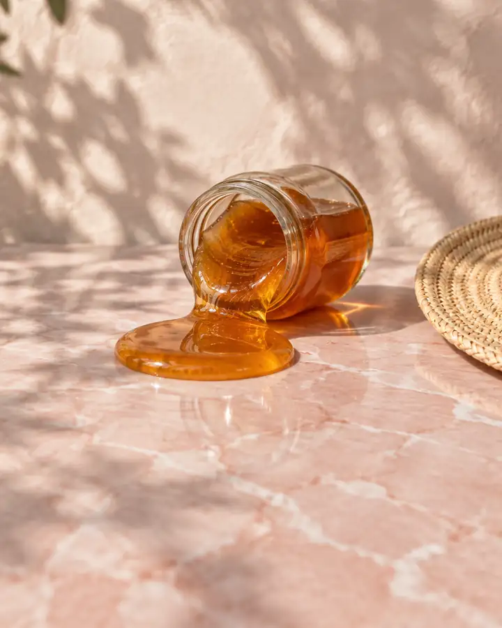 Still life: a tipped jar of sugar paste beside a straw hat